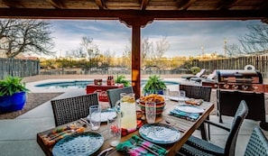 Grill, outdoor dining, and patio furniture make for a splendid poolside retreat.