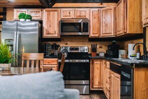 The kitchen features modern, stainless steel appliances