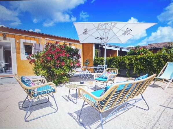 coin repas + salon de jardin pour apéro avec vue sur piscine au son des cigales