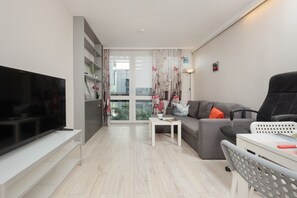 Open-plan living and dining area with elegant furnishings and access to a balcony.