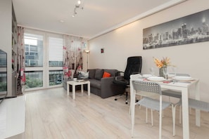 Dining area with a small table, stylish chairs, and a vibrant floral centerpiece for a welcoming touch.