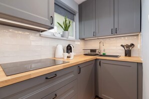 Modern kitchen with gray cabinets, subway tile backsplash, and convenient appliances.

