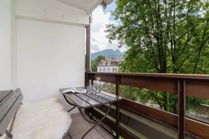 Private balcony with seating, offering a peaceful view of lush greenery.


