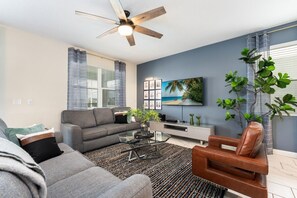 Relax in this stylish living room with cozy seating, a sleek TV setup, and vibrant decor—perfect for unwinding after a day of exploring.