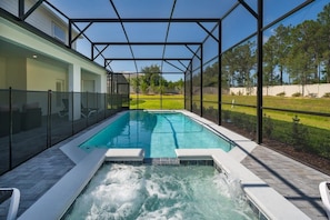 Relax in your private screened pool and hot tub with serene views of lush greenery.