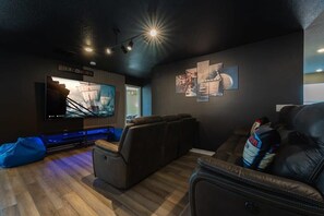 Experience ultimate comfort in this stylish game room with plush seating and a large screen for immersive entertainment.