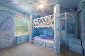 Step into a magical Frozen-themed bedroom with custom ice-like bunk beds, perfect for a whimsical stay!