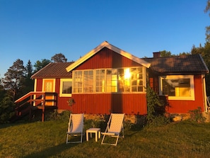 Red holiday cottage, front on a summer evening