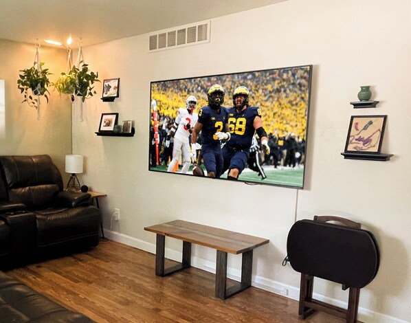 Living area #1 with 72" flat screen tv and recliner couches.