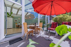 Sonnige Terrasse mit Gartenmöbeln und Sonnenliegen