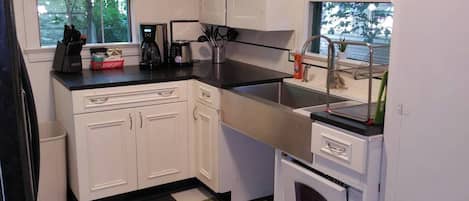 Honed Granite Countertops with $1100 Stainless Steel Farmsink in this updated kitchen. Open area underneath sink was designed as a pet feeding station. Pico Remote control at the back door runs the Welcome Home Scene, Relax Scene and All Off Scene. Never walk in the dark in this Townhome!    