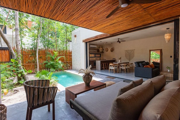 Private patio with plunge pool, lush greenery, and a cozy seating area.