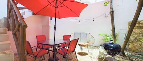 Beautiful patio equipped with a BBQ, multiple chairs, a dining table and a bench with side table