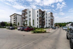 Exterior view of the modern apartment complex with convenient parking and landscaped surroundings.

