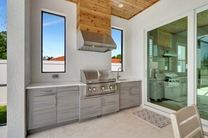 Indulge in alfresco dining with our built-in grill, spacious counter space, and rustic knotty cypress ceiling