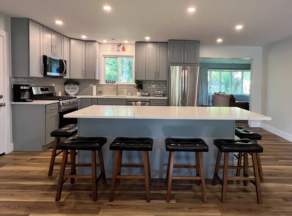 An oversize kitchen island has sitting for six and is great for being together.