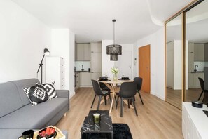 Open living and dining space with warm wood flooring and chic interior accents.

