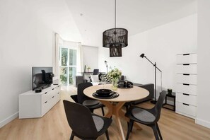 Dining area with a round table, black chairs, and a decorative lamp for a cozy atmosphere.

