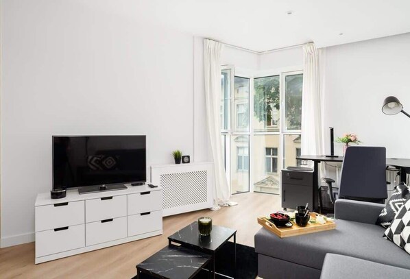 Spacious living area with a stylish coffee table, cozy décor, and ample natural light.


