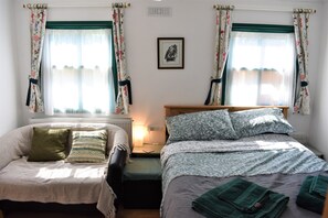 A comfy double bed and sofa in the bright living area.