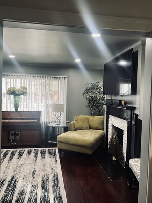 (pic 3 of 3) Living room w/natural fireplace.  Also Bluetooth ceiling speakers