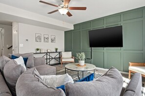 Cozy sectional sofa, 65" TV, base green accent wall