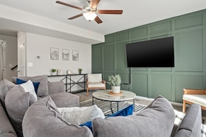 Cozy sectional sofa, 65" TV, base green accent wall