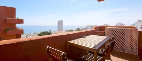 Apartment terrace with outdoor dining area for four guests and beautiful sea views