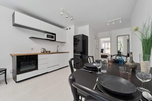 Open dining and living area with stylish furniture and a contemporary kitchen in the background.

