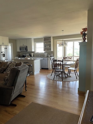 View of the living, kitchen, and dining area from front entry into the house.