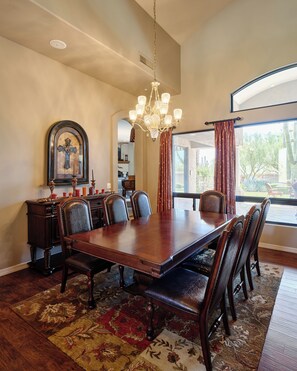 Grand front entrance featuring formal dining area for up to 7 guests, high ceilings, oversized windows providing natural light, and furnishings for lounging.
