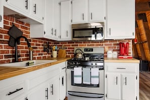 The kitchen is equipped with everything you might need to make that perfect meal: stainless steel pots and pans, cookie sheets, baking pans, steak knives, and a selection of cooking utensils