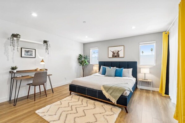 Spacious and bright master bedroom with blackout curtains, connected bath and desk area for working