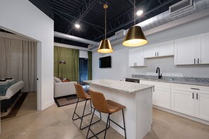 Where style meets functionality. Discover this exquisite kitchen with a centrally placed bar area and modern stools that effortlessly blend form and function. Whether you're hosting a casual brunch or savoring a quiet meal, this trendy setup creates the perfect balance of aesthetics and practicality.