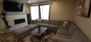 The spacious living area features a fireplace and TV for a great movie night or relaxing in front of the fire.