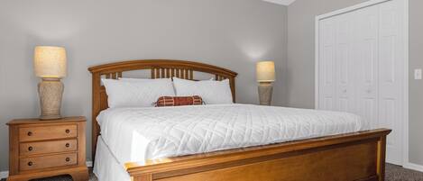 King sized master bedroom with nightstands and lamps on bedside. 