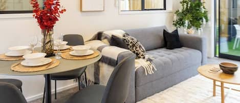Dining and Living Area - Comfortable Couch, Dining Table and Dishes available for Guests.