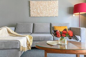Modern decor features wooden tables and sleek neutral furnishings complemented with fun pops of red decor