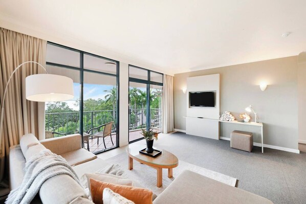Enjoy leisurely evenings in the inviting living area, complete with a TV for entertainment and seamless access to the adjoining balcony, perfect for soaking up the surrounding views.