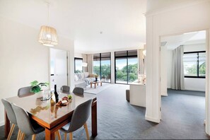 A spacious kitchen sits alongside a comfortable and well-lit living area as well as a dining area for six guests
