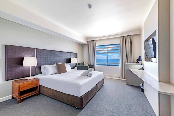 Rays of light stream into the spacious studio through a large window showcasing tranquil views of the sea