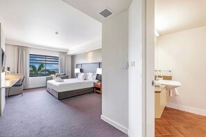 Rays of light stream into the spacious studio through a large window showcasing tranquil views of the sea.