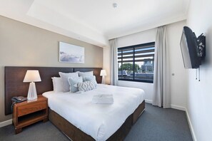 A light-filled king room is complemented by a large window showcasing views of Darwin city and its surroundings
