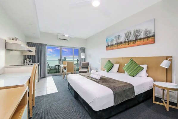 The naturally-lit studio features a plush king bed, built in wardrobes and the convenience of air conditioning