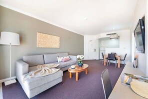 Kick back in the living room. It’s fitted with generous sofa seating with a TV, a dedicated workspace and dining table set for four.