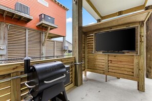 65 inch outdoor TV with soundbar and Traeger wood pellet grill