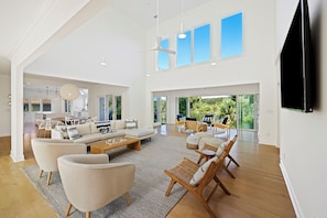 Spacious living room with tons of natural light, vaulted ceilings and lots of comfortable places to sit.