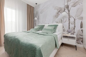 Stylish bedroom with a green bedspread, modern decor, and a feature wall.

