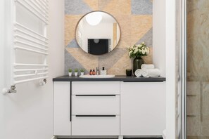Contemporary bathroom with a round mirror, sleek vanity, and fresh decor accents.

