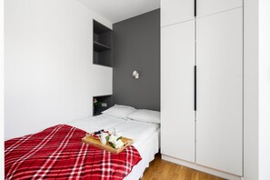 Compact bedroom with a cozy bed and built-in storage, offering a functional design.

